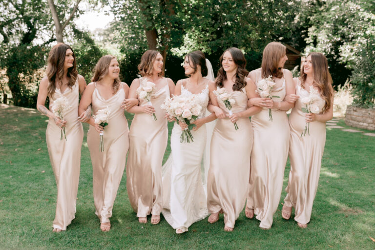 JA - By Catherine Carter Weddings-103 Elegant Bride with her six bridesmaids holding their bouquets of blush pink roses in the garden of Millbridge Court, Surrey.